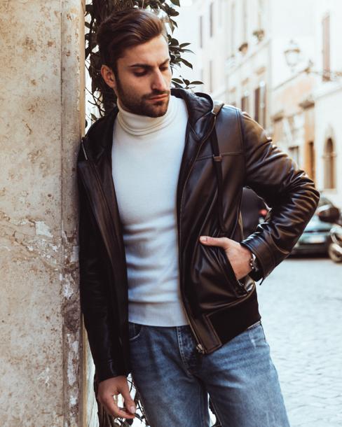 Dolce è una giacca sportiva in pelle di agnello nera da uomo con cappuccio e fodera trapuntata. È sartoriale e molto aderente, con un elastico sul fondo.